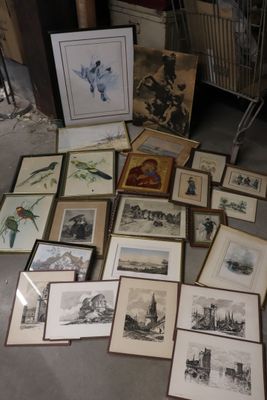 a lot of framed pictures on the floor of a room