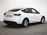 a white tesla suv parked in a white room with checkered floor