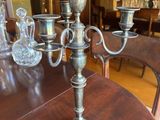 a silver candelab on a wooden table in a dining room