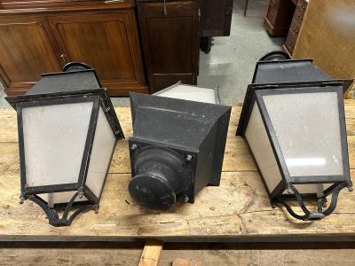 trois lanternes noires posées sur une table en bois dans une pièce