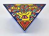 objet de forme triangulaire aux couleurs vives, avec un visage au centre