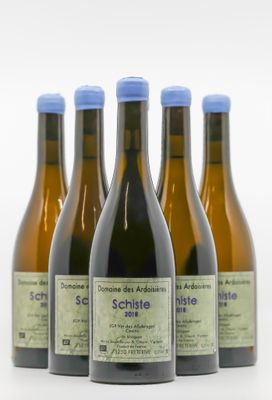 quatre bouteilles de vin sont alignées sur une surface blanche