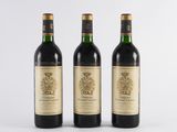 three bottles of wine sitting next to each other on a white surface