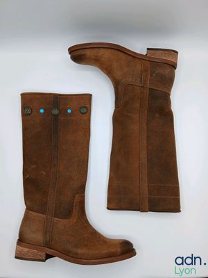 a pair of brown boots sitting on top of a white surface