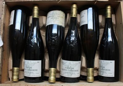 six bottles of wine are in a wooden box on a table