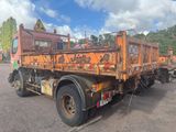 a rusted orange truck parked in a parking lot