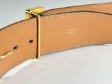 a close up of a tan leather belt with a gold buckle