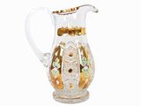 un pichet en verre transparent orné de motifs dorés