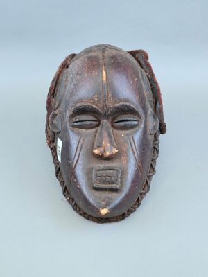 une image représentant un masque en bois sur un fond blanc