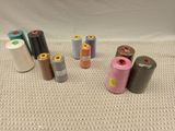 several spools of different colors of thread on a white surface