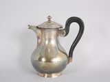 a silver coffee pot with a black handle on a white background