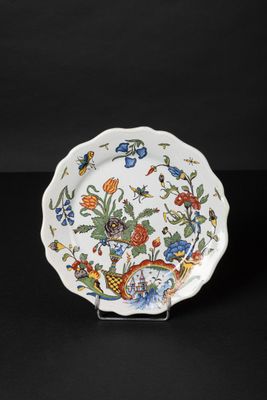 a close up of a plate with flowers and birds on it