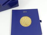 a close up of a blue book with a gold coin on it