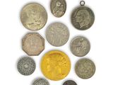 an assortment of coins and pendants on a white surface
