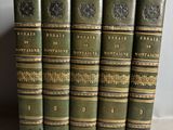 cinq vieux livres posés les uns à côté des autres sur une table