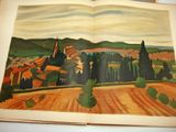 an open book with a picture of a village in the middle of it