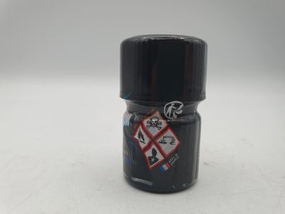 une bouteille noire avec un autocollant, posée sur une surface blanche