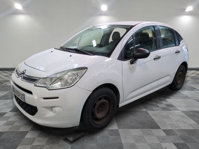 la petite voiture blanche est garée sur un carrelage à carreaux