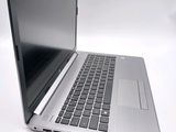 a silver laptop with a black keyboard on a white surface