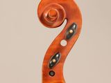 a close up of a violin ' s neck with a fiddle in the background