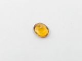 a close up of a yellow gemstone on a white surface