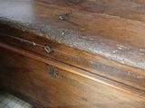 a very old wooden chest sitting on a tiled floor
