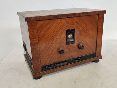 une vieille radio en bois posée sur un meuble blanc