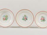three plates with floral designs on them sitting on a white surface