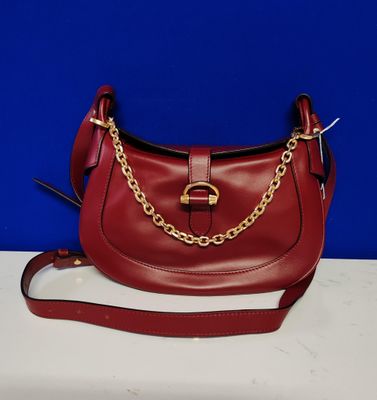 un gros plan d'un sac à main rouge posé sur une table blanche