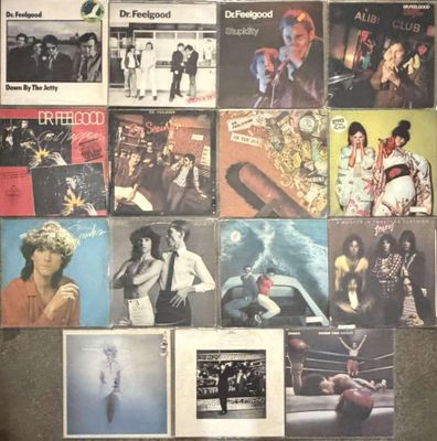 many different album covers on the wall of a room