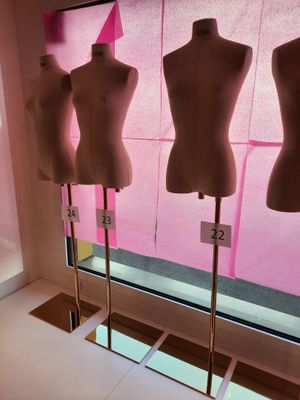 trois mannequins exposés devant une vitrine