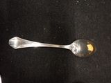a silver spoon with a spoon handle on a black surface