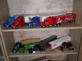 il y a beaucoup de petits camions jouets sur les étagères de la pièce