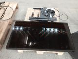 a black television sitting on a pallet next to a wooden pallet