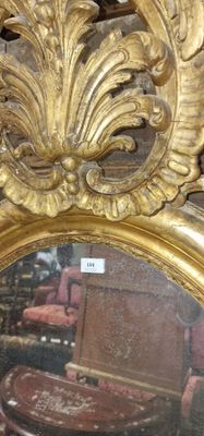 un miroir avec un cadre doré et une chaise rouge en arrière-plan