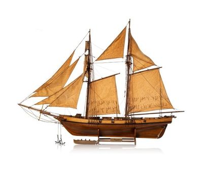a wooden model of a sailboat on a white surface