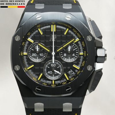 a close up of a watch with a black face and yellow accents