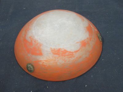 an orange and white helmet sitting on a black surface