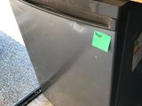 a silver refrigerator with a green sticker on it
