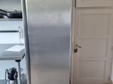 a stainless steel refrigerator in a kitchen with a checkered floor