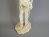 une statue blanche représentant un homme tenant une batte de baseball