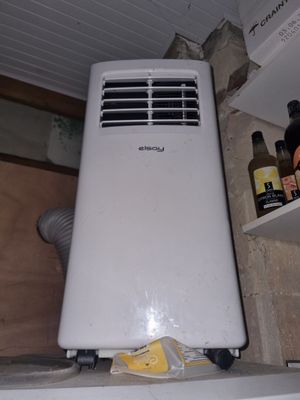 un climatiseur blanc posé sur une étagère dans une pièce