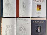 four books with drawings of women and men on them sitting on a table