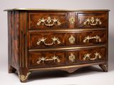 une grande commode en bois ornée de motifs dorés