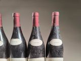 three bottles of red wine are lined up on a table