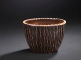 a close up of a wooden bowl on a black surface