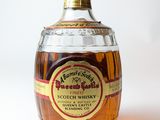 une bouteille de bourbon posée sur une surface blanche
