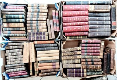 boxes of old books stacked on top of each other on a floor