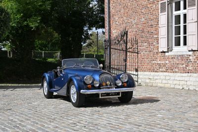 a blue car that is parked in front of a brick building