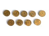 several gold coins are arranged in a row on a white surface